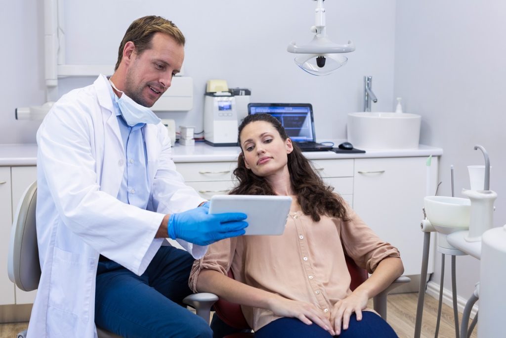 dentist showing information to his patient