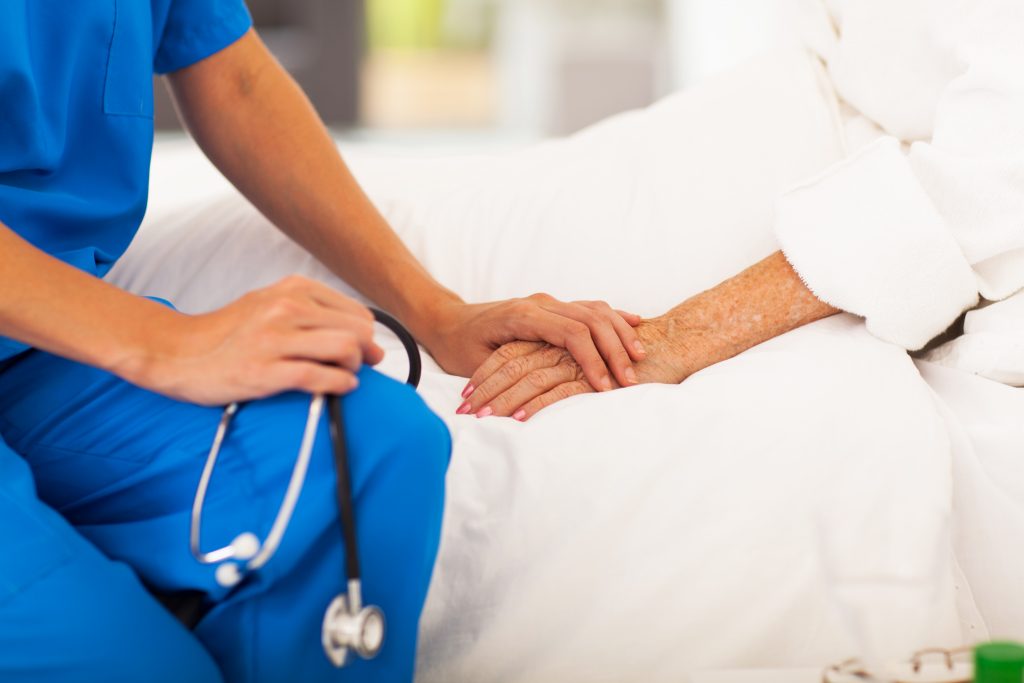nurse holding a patient's hand