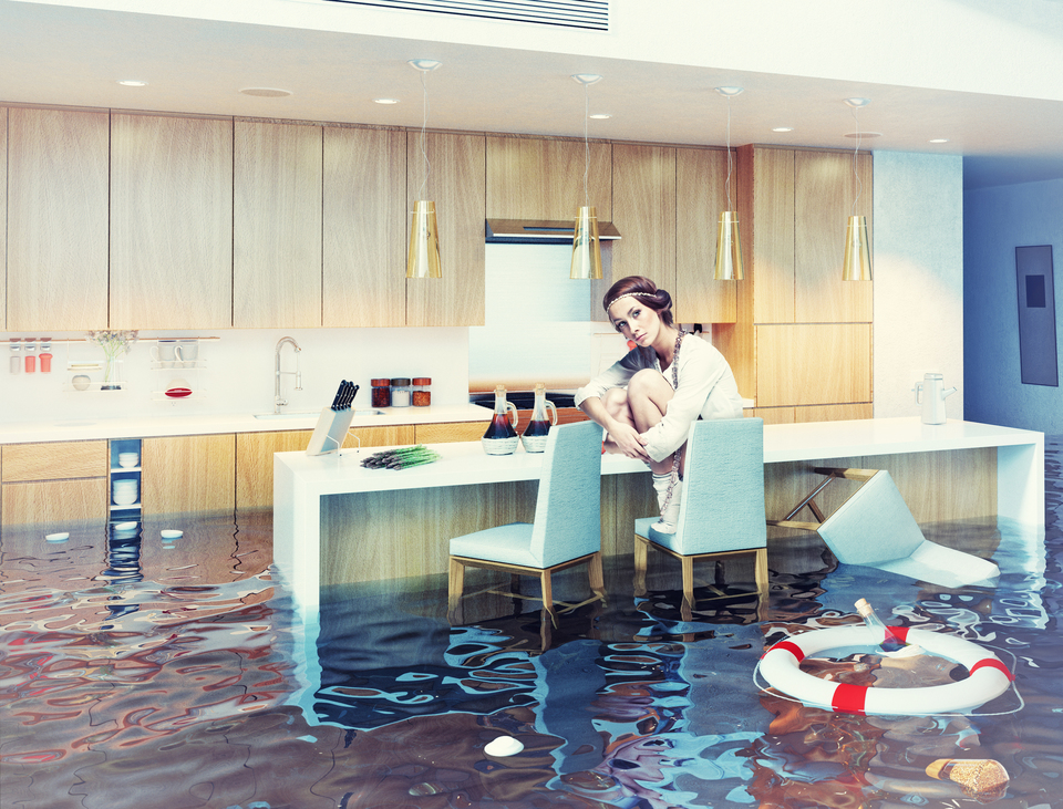 A woman sitting in a flooded kitchen