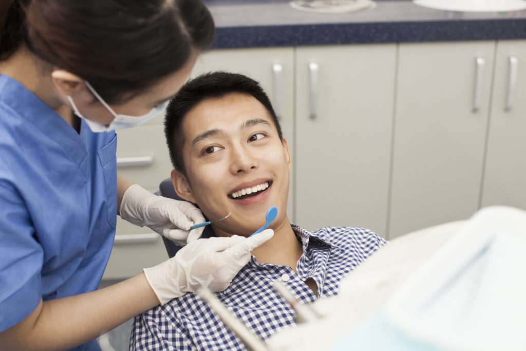 Man being checked by a dentist