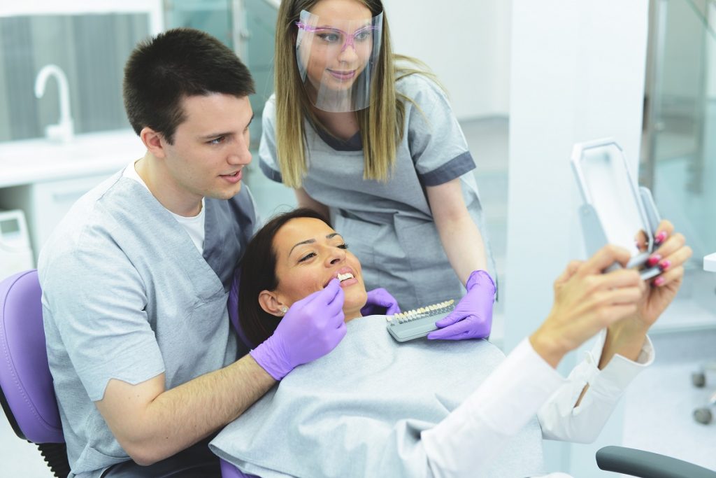 Dentist showing the patient new implanted teeth