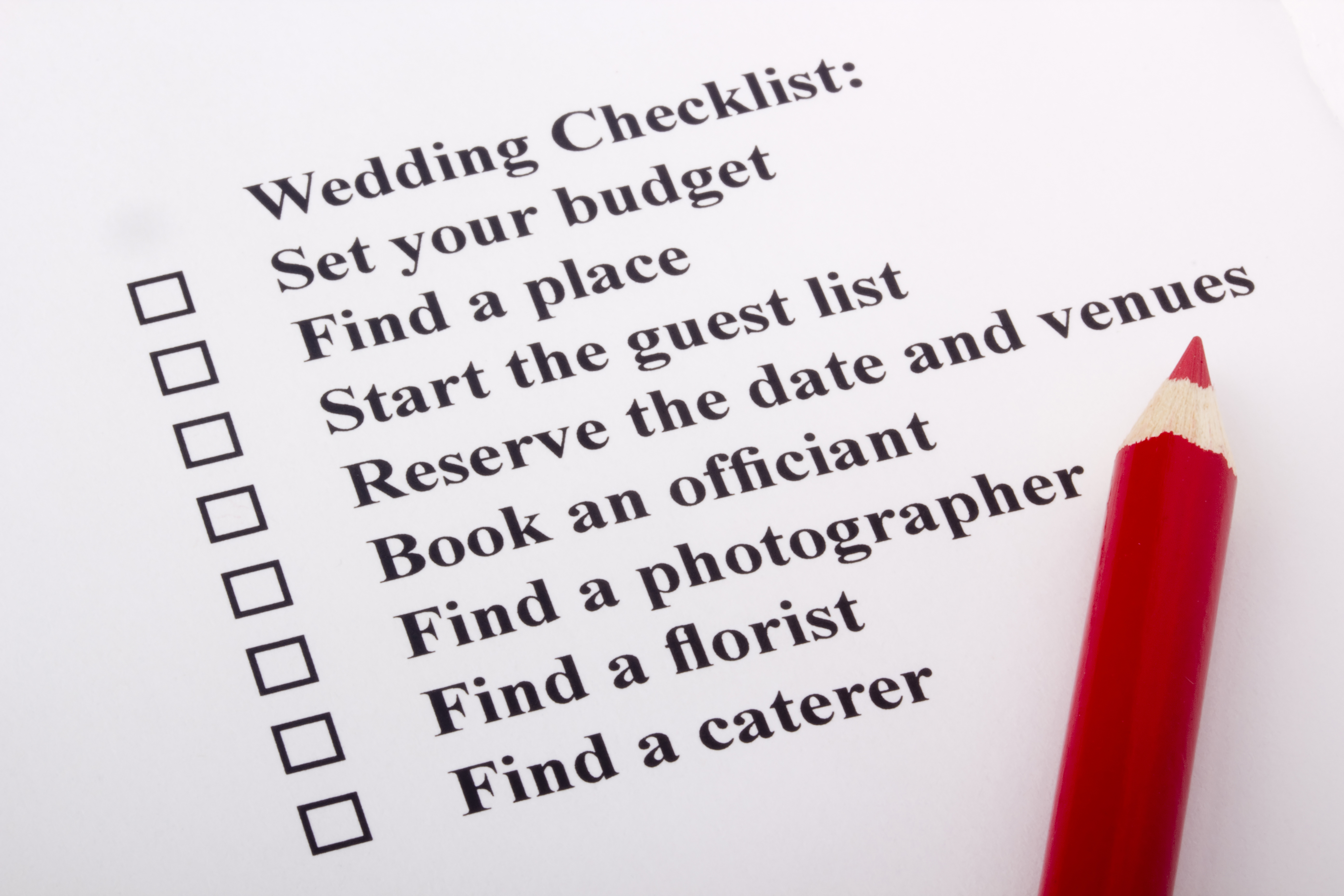 Red pencil laying on a wedding checklist