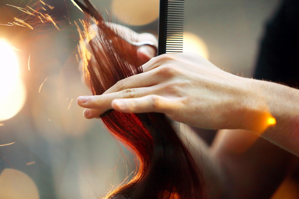Hairdresser cutting brown hair