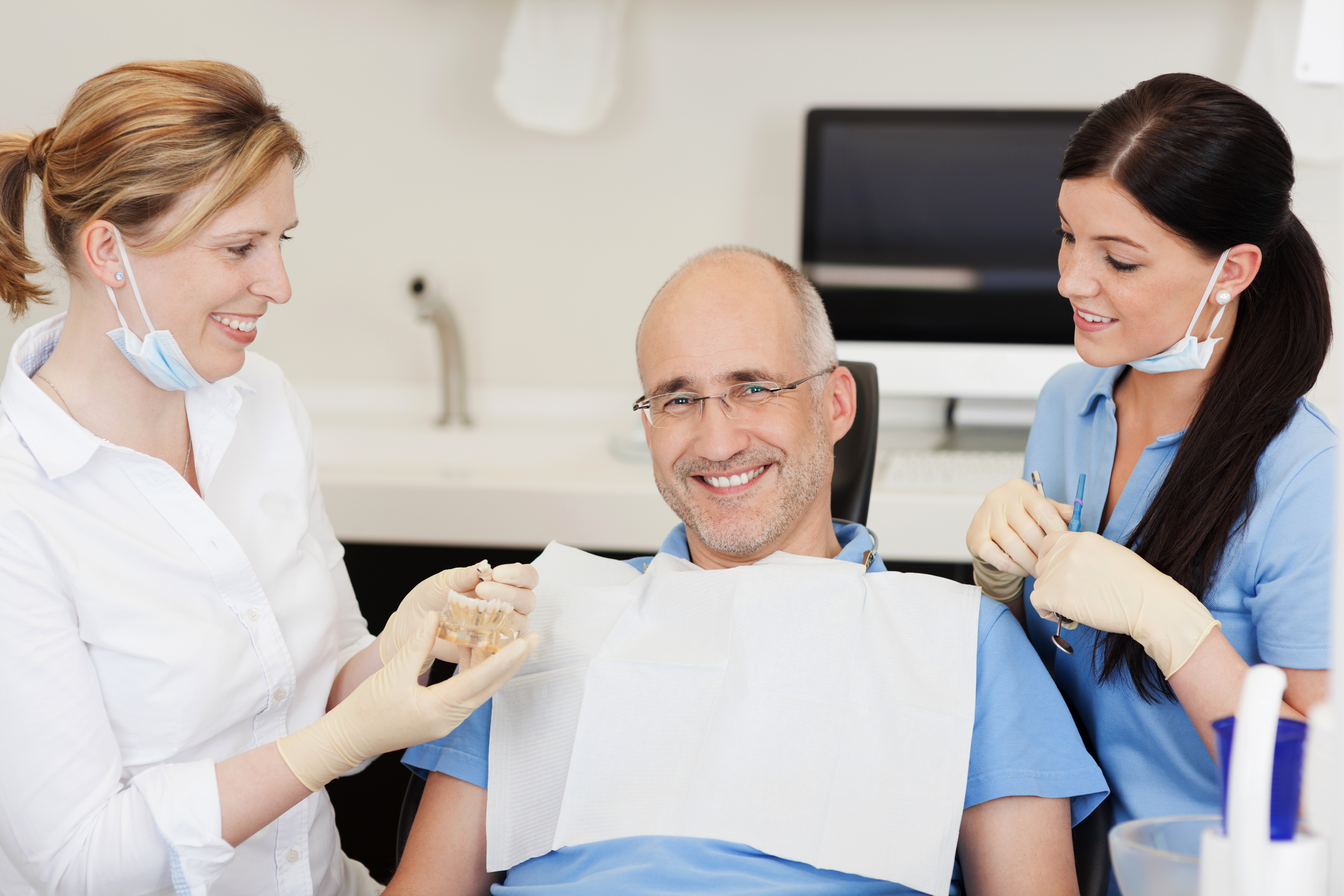 Man being checked by two dentists