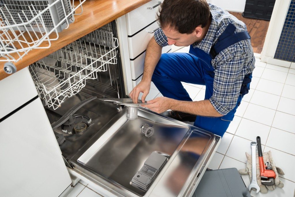 a man repairing the dishwasher