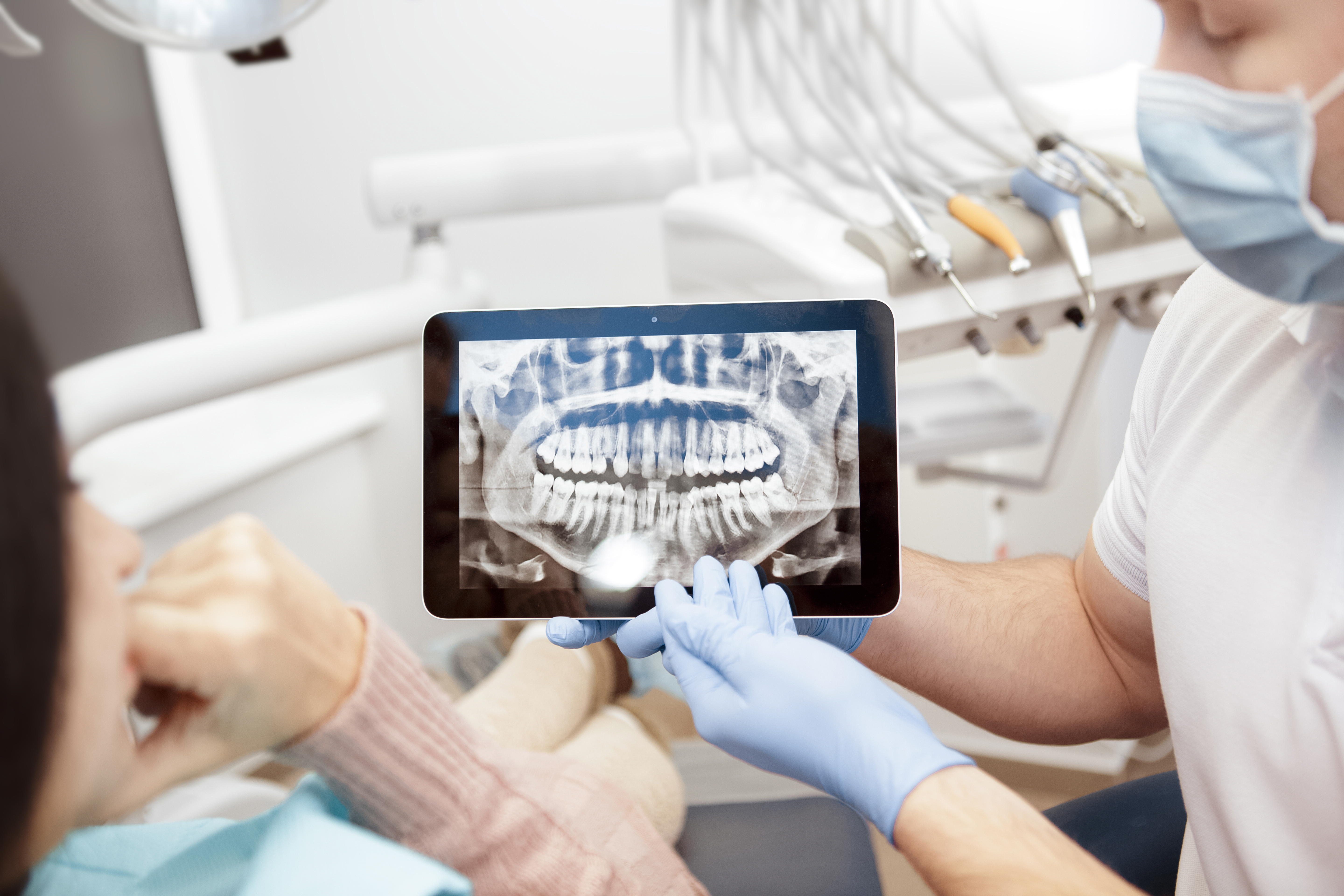 Dentist explaining area of surgery using an x-ray