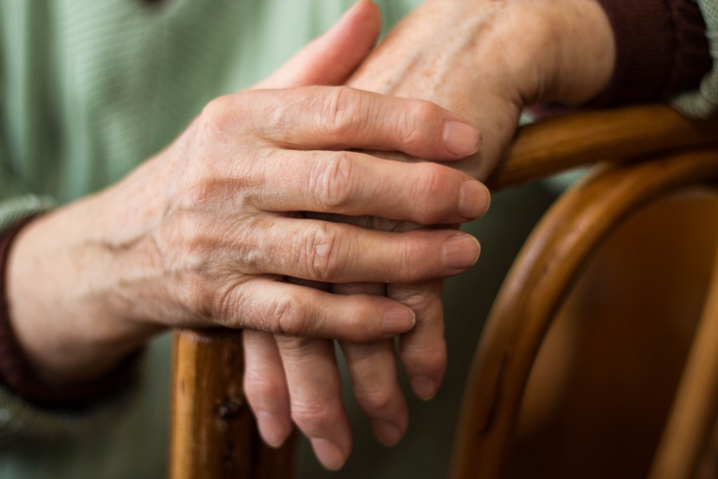 elderly person holding both her hands