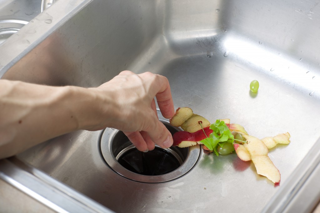 a man pulling out wastes that clogs the sink