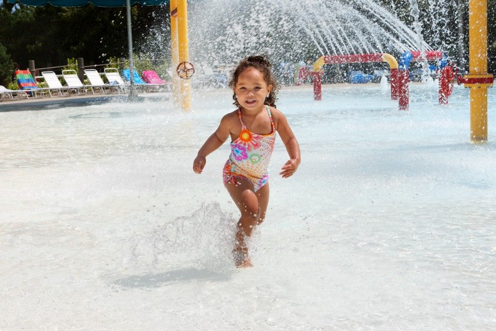 little girl playing at a water park