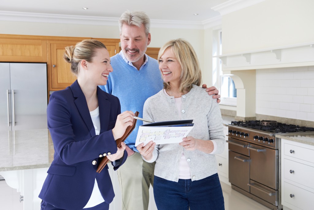 Broker touring a middle-aged couple around a house