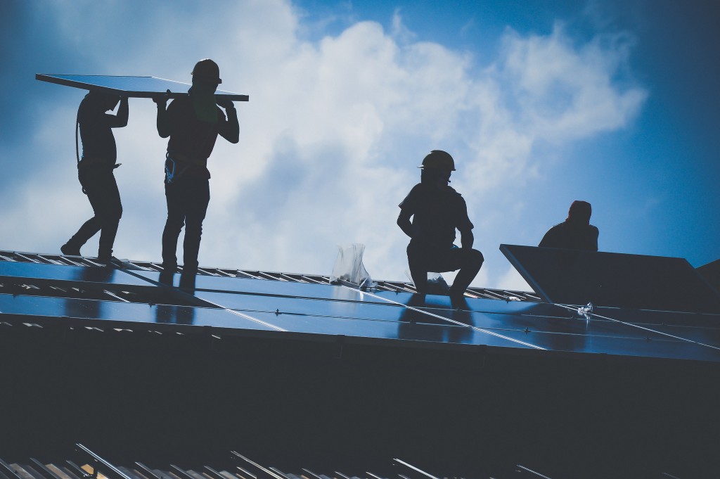 Workers intalling solar panels on the roof