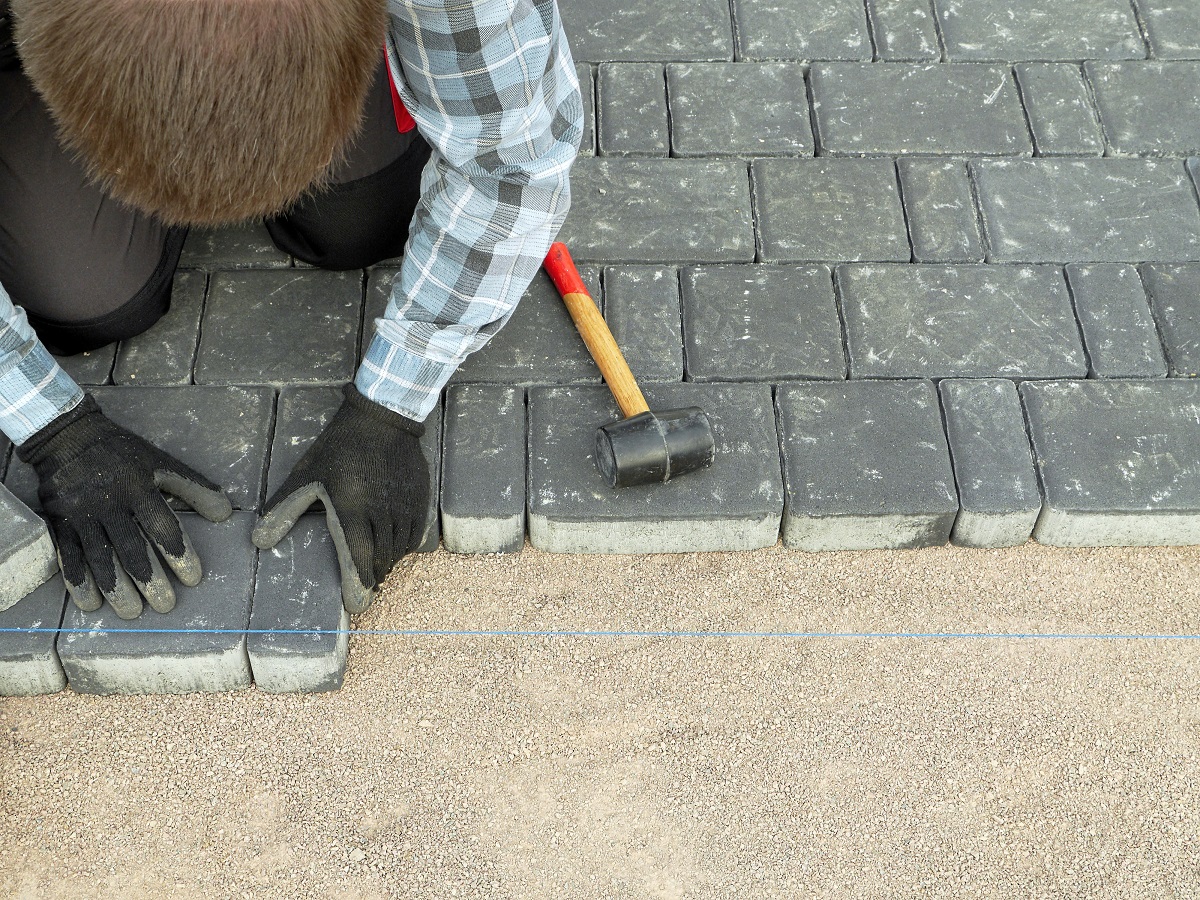 Worker laying pavement blocks