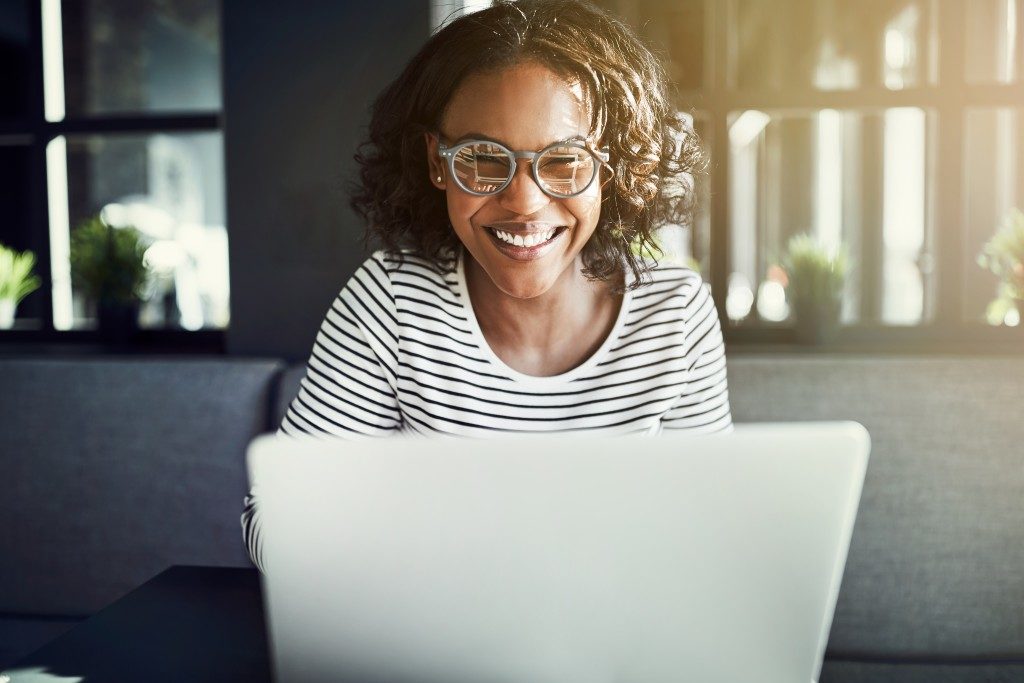 woman smiling at her laptop