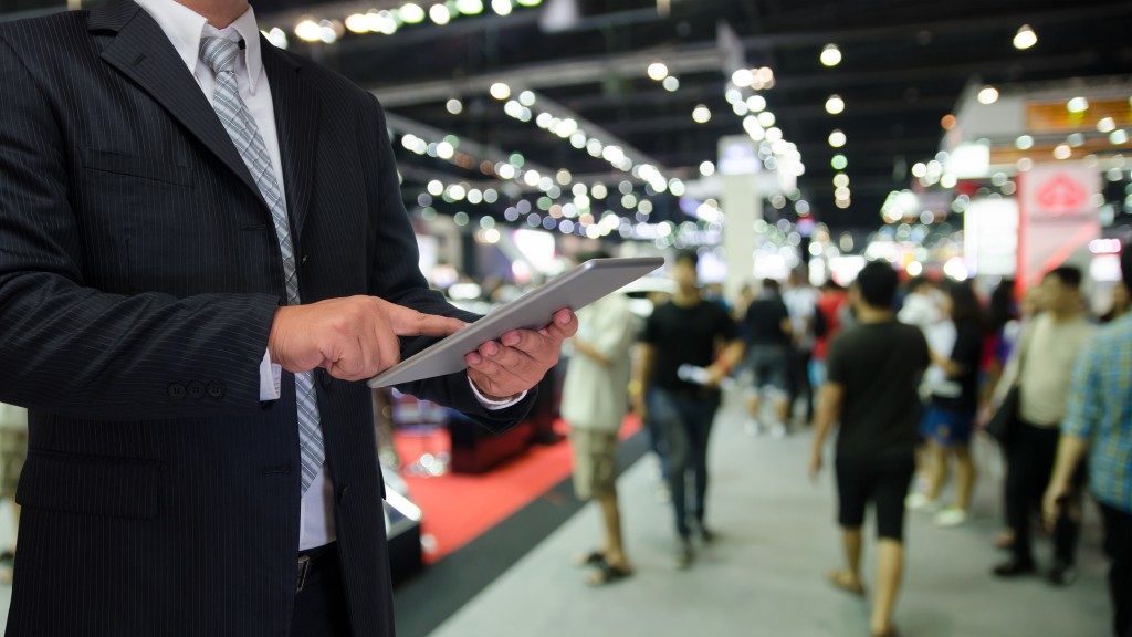businessman at a convention looking at his tablet