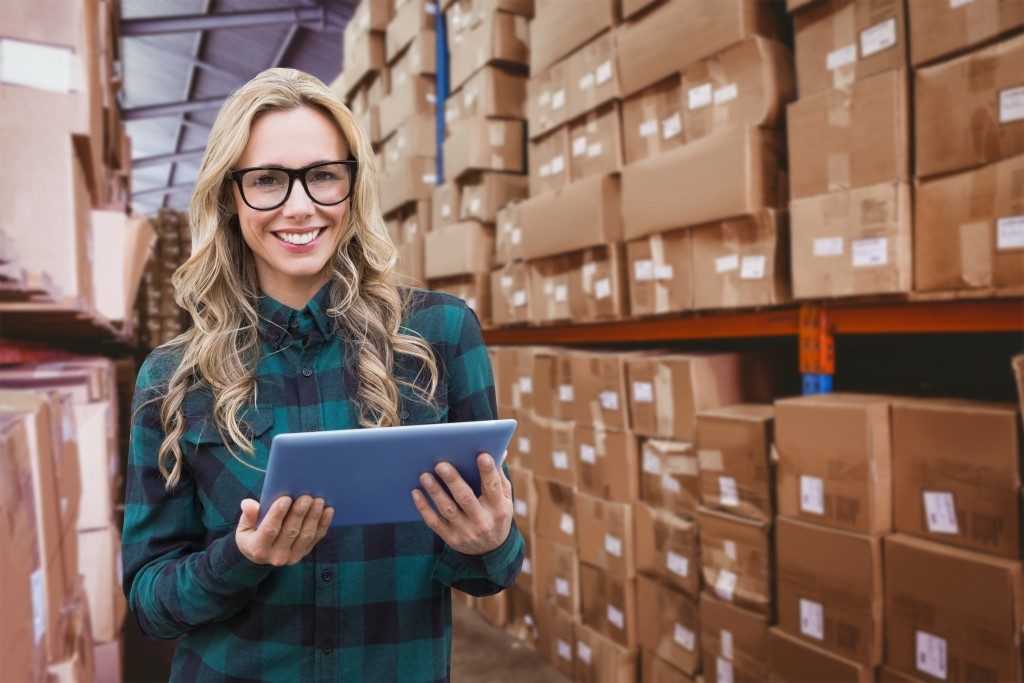 woman holding a tablet inside the warehouse