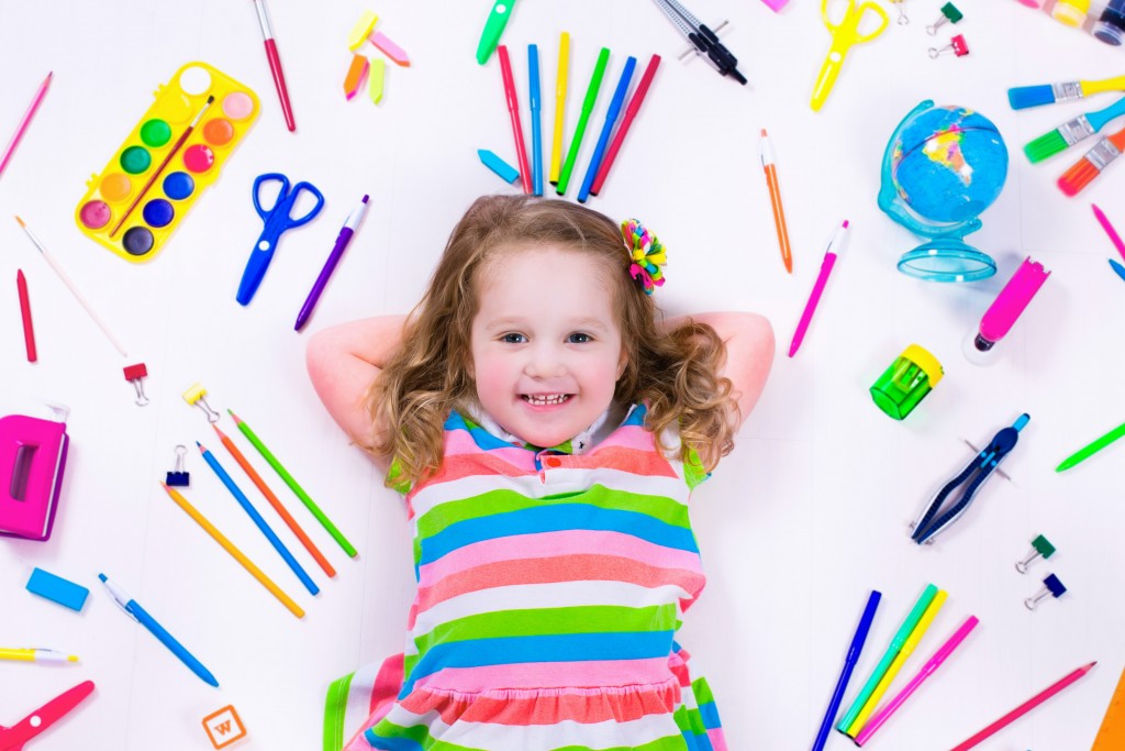 kid surrounded by art materials