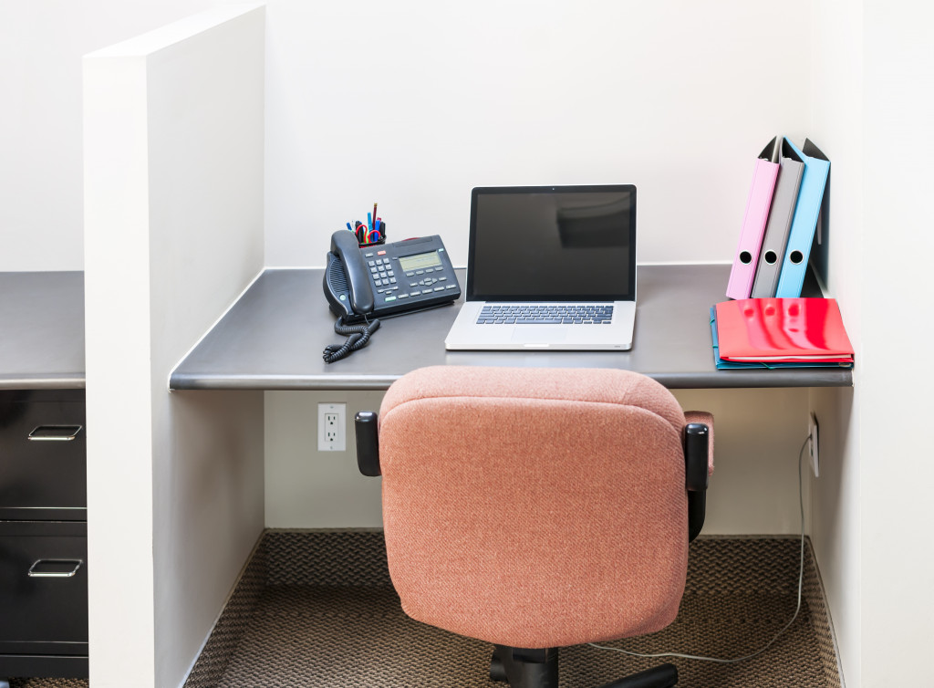 Workstation in office with swivel chair desk and laptop computer