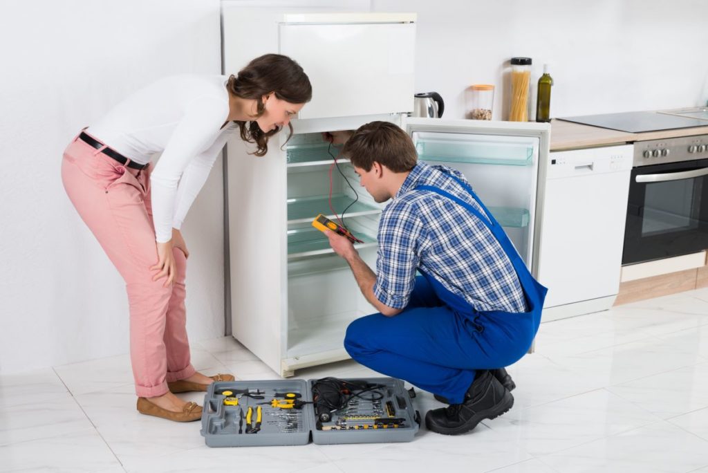 technician working on refrigerator