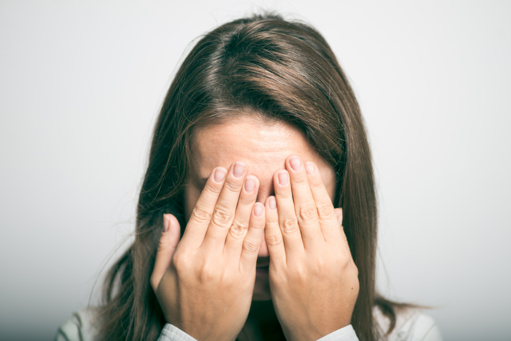 woman crying with her hands covering her face