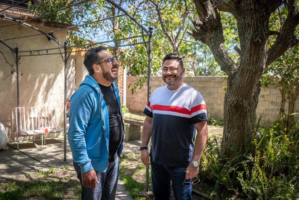 Two men having a conversation in the backyard