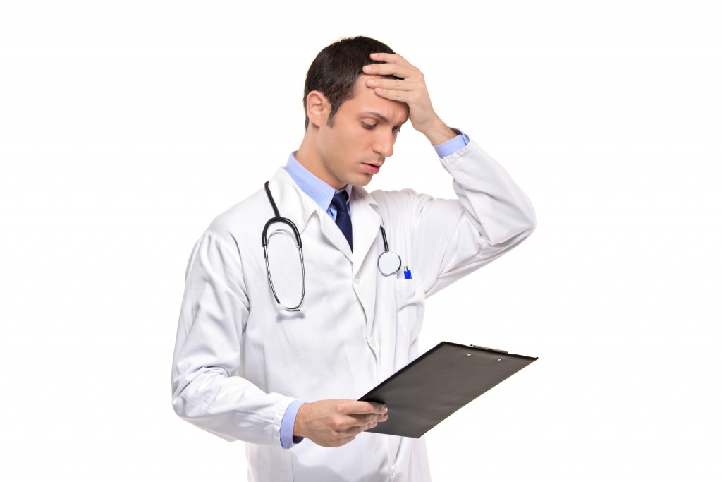A doctor banging his head realizing a mistake