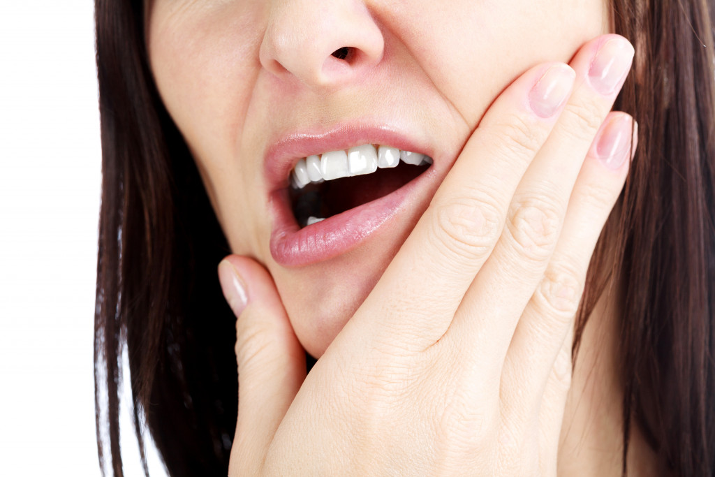 A woman holding her jaw and experiencing jaw pain