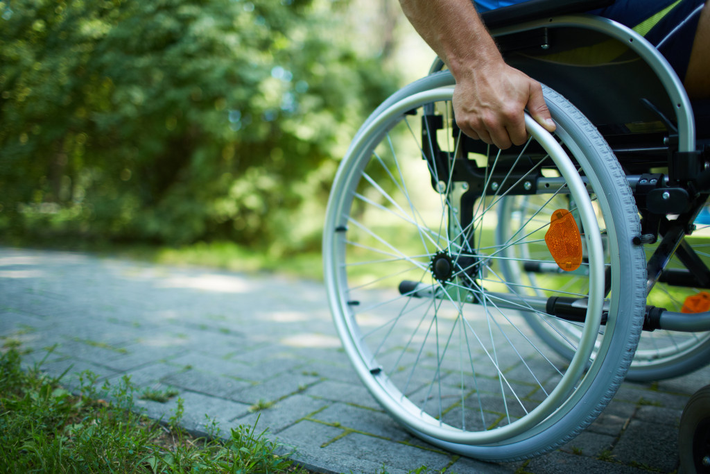 male hand on wheel of wheelchair