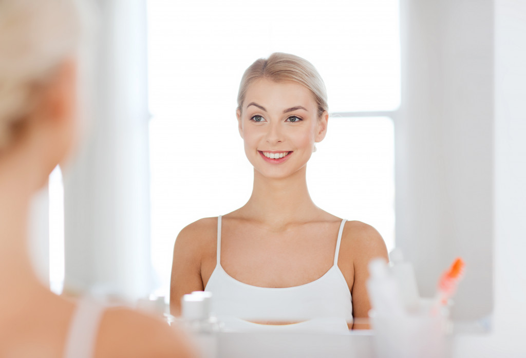 a woman smiling in front of the mirror