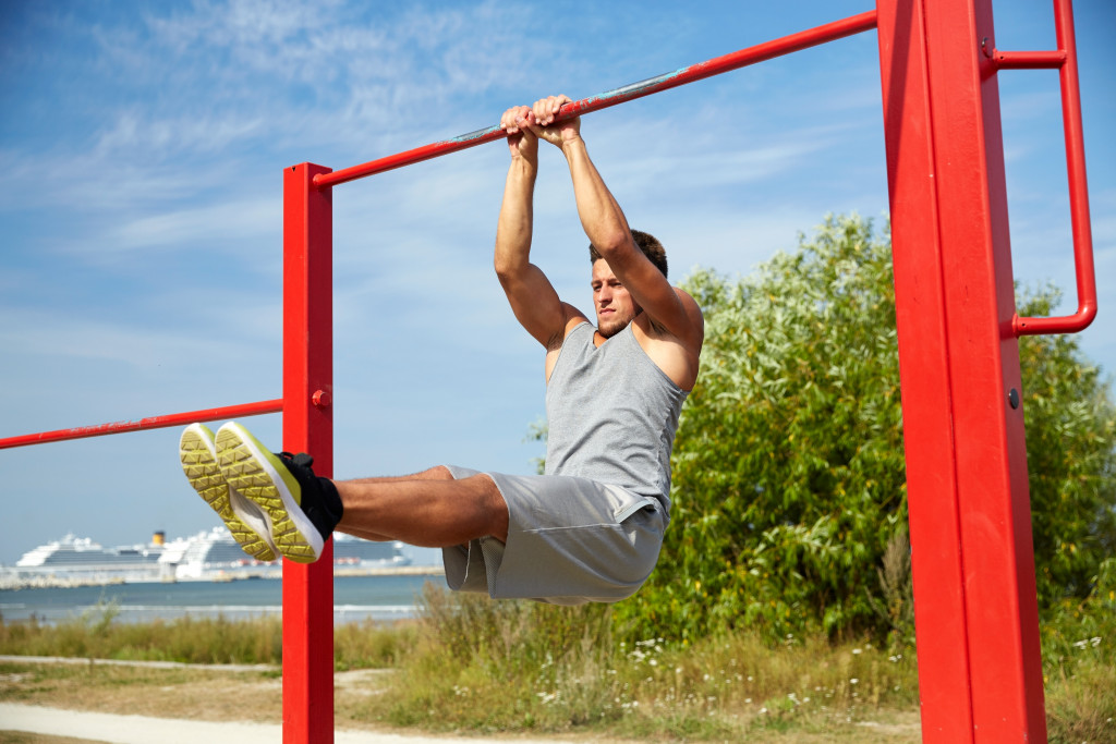 Outdoor fitness, a man doing exercise on a monkey bar