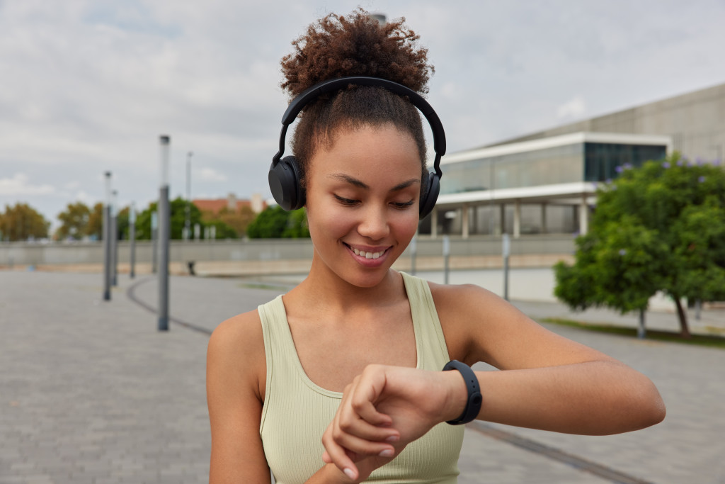 woman wearing smart watch while exercising outdoors