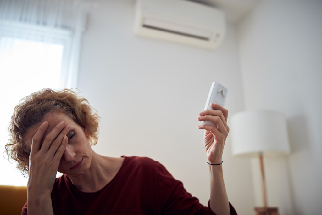 woman holding aircon remote